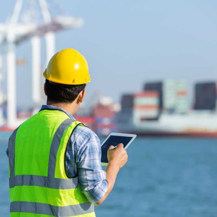 Port logistics manager with tablet coordinating shipment